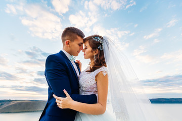 the newlyweds embraced and closed their eyes. riverbank and the