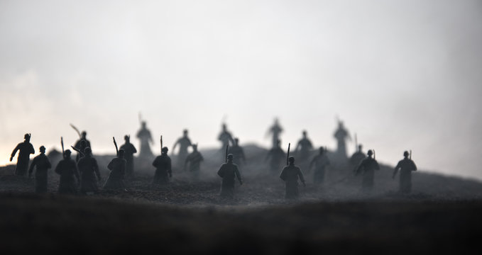 War Concept. Military silhouettes fighting scene on war fog sky background, World War Soldiers Silhouettes below Cloudy Skyline at sunset. Attack scene. Armored vehicles.