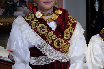 Girl dressed in traditional regional folk costumes in the church at the Mass on Thanksgiving day in...