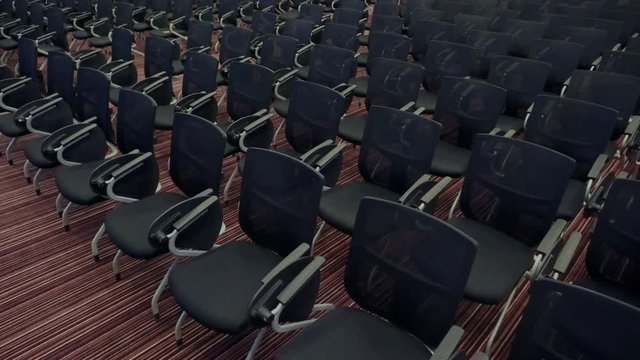 Camera moves among a lot of comfortable seats in empty audience hall. Preparing for the conference in the big auditorium. Slider shoot of big hall for business meetings