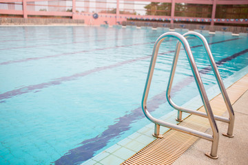 Ladder stainless handrails for descent into swimming pool. Swimming pool with handrail . Ladder of...