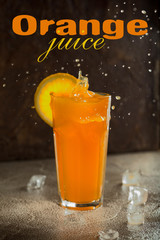 Glass of orange juice and slices of oranges on a dark background. Selective focus.