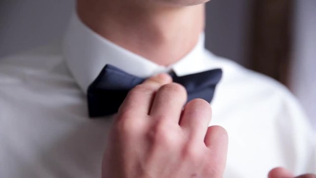 Businessman putting on bow tie,man butterfly clothes,groom getting ready in the morning before wedding ceremony. Men Fashion.