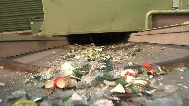 Medium fractures of waste glass on a conveyor belt in MRF facility.