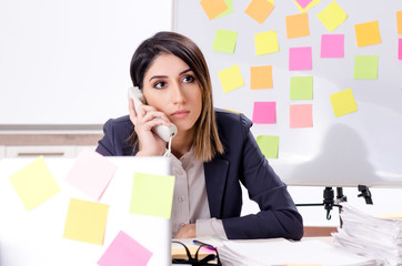 Young female employee in conflicting priorities concept 