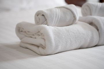 Obraz na płótnie Canvas Stack of white bath towels on bed sheet