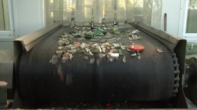 Small fractures of waste glass on a conveyor belt in MRF facility.