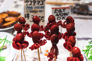 Tako Tamago, baby octopus on a stick. A japanese street food specialty, baby octopus with a quail egg inside, candied and skewered.
