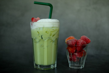 Close up milk froth green tea with fresh strawberry