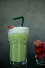 Close up milk froth green tea served with fresh strawberry