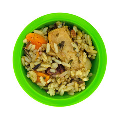 Chicken with pecans and wild rice in a small green bowl isolated on a white background