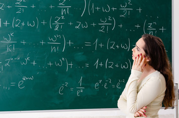 Young female math teacher in front of chalkboard  