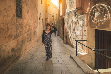 Obraz na płótnie Canvas Beautiful asian woman tourist walking on the street in the old town of Rabat , malta