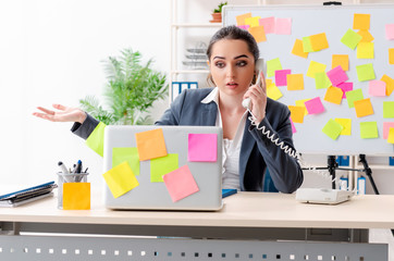 Young female employee in conflicting priorities concept 