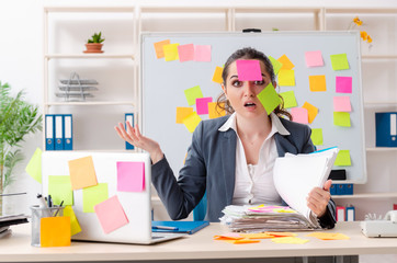 Young female employee in conflicting priorities concept 