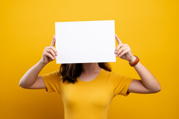 Woman covering face with blank paper