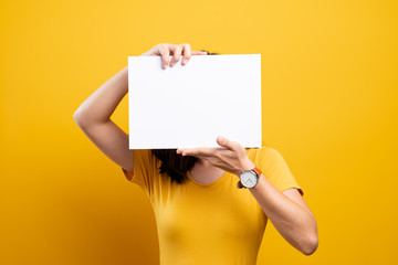 Woman covering face with blank paper