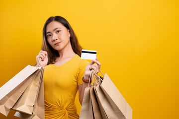 Fototapeta na wymiar Portrait of woman holding shopping bags and credit card isolated over background