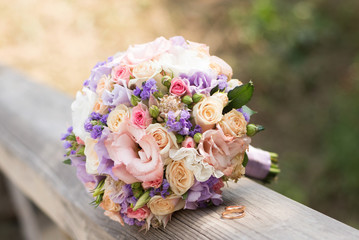 Beautiful wedding rings with bouquet of flowers. Declaration of love, spring. Wedding card, Valentine's Day greeting. Wedding rings. Wedding day details