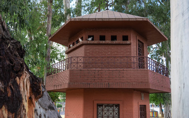 birds standing on a bird house tower in a spanish park
