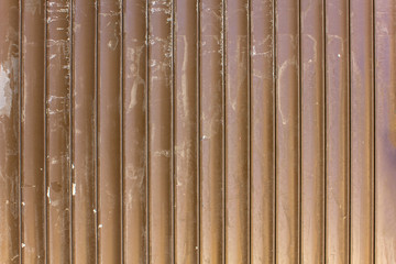Old dirty brown yellow gray metallic blinds with white spots of paint. vertical lines. rough surface texture