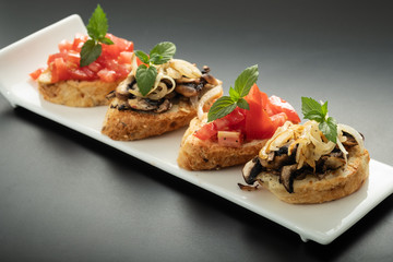 Fresh bruschetta assorted. Serve on a white plate. Order in the menu