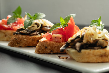 Fresh bruschetta assorted. Serve on a white plate. Order in the menu