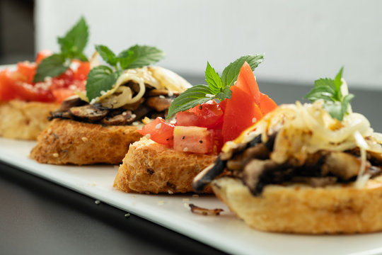 Fresh bruschetta assorted. Serve on a white plate. Order in the menu