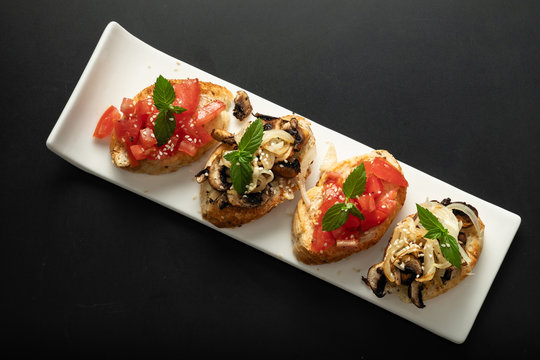 Fresh bruschetta assorted. Serve on a white plate. Order in the menu