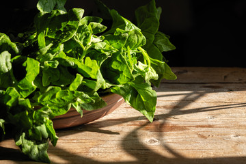 Fototapeta premium green fresh bunch of spinach in a beautiful cup on a wooden background
