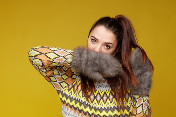 Mixed raced young female model posing indoor over yellow studio wall background for advertising,...