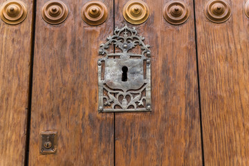Detail of an old and large lock and a small and modern lock at the bishopric door in the old town...