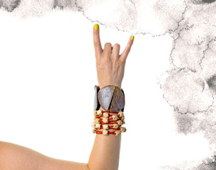 Female hand decorated with wooden braclets showing rock’n roll sign. Isolated on white backgroud.