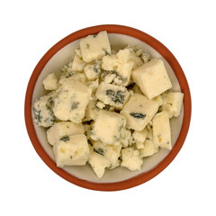 Small bowl filled with chunks of blue cheese on a white background top view