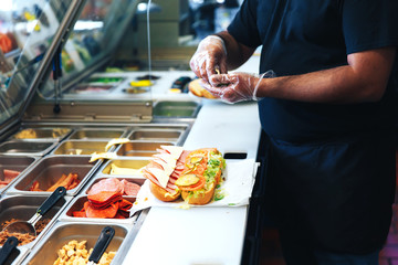 Fototapeta preparing sandwich in the restaurant. the kitchen of fast food restaurant obraz