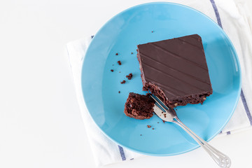 Homemade dark chocolate vegan brownie cake with nuts plate light background. Selective focus.