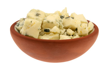 Small bowl filled with chunks of blue cheese on a white background