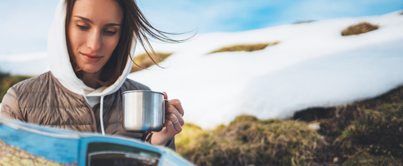 people planning trip in snow mountain, girl hold in hands cup of drinks, relax tourist look on map,...