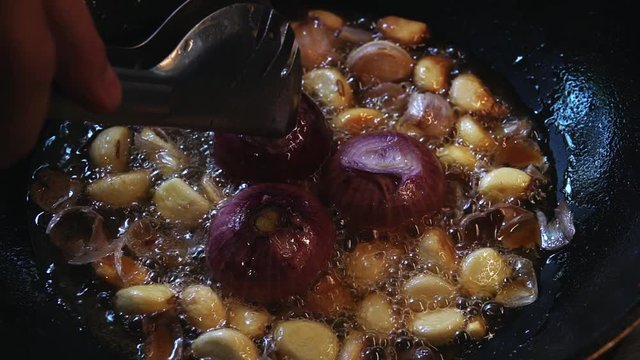 Cook Deep Frying Whole Onion and Garlic in Oli in Wok
