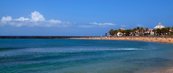 Fototapeta premium Panorama view of Playa del Camison beach with turquoise water and yellow sand in Las Americas, Tenerife,Canary Islands,Spain.Travel or vacation concept.