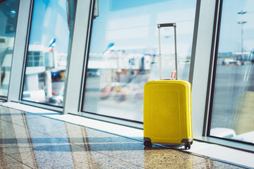 isolate traveler tourist yellow suitcase at floor airport on background large window, luggage...