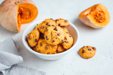 Pumpkin cookies with chocolate chips made from cake mix in a white ceramic bowl.