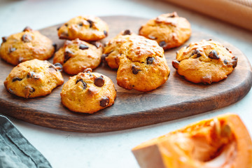 Pumpkin cookies with chocolate chips made from cake mix on a wooden tray.