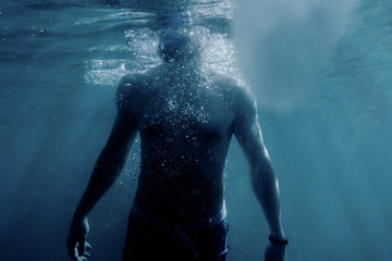 Freediver man swimming to the surface of sea.