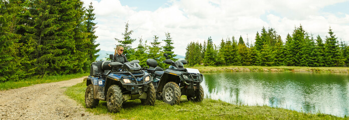 Excited young woman on quad bike. Happy young woman driving all terrain vehicle in nature. © Angelov