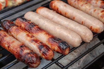 Raw and Cooked Sausages on a Barbecue Grill