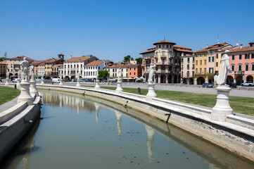 Beautiful summer day on Prato della Valle square with water canal. Amazing italian sculptures.