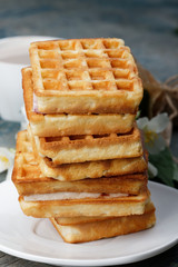 Stack of Viennese waffles on wooden background. Waffles on a white plate, wooden rough blue background.