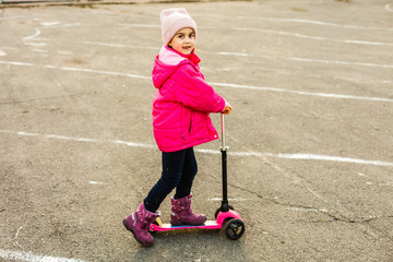 Child riding scooter. Kid on colorful kick board. Active outdoor fun for kids. Summer sports for...