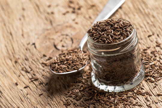 Caraway grain in the jar, vintage wooden background, selective focus